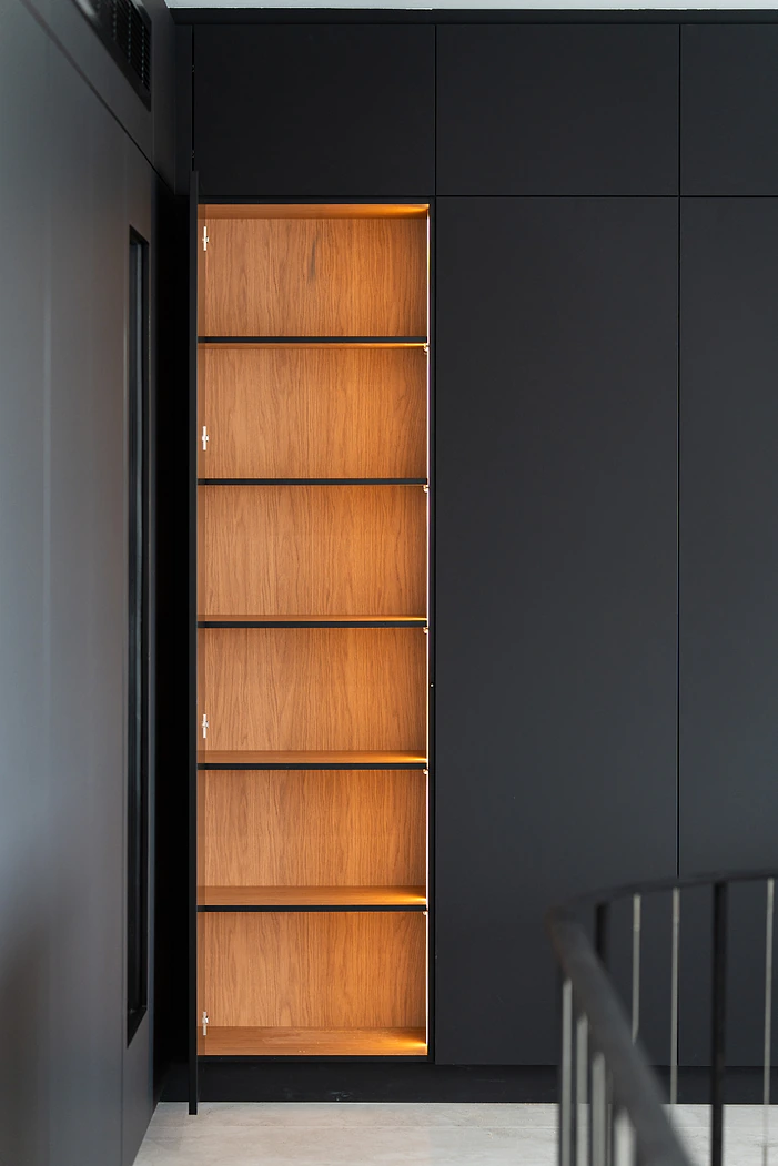 Black cabinetry with lit timber display shelving