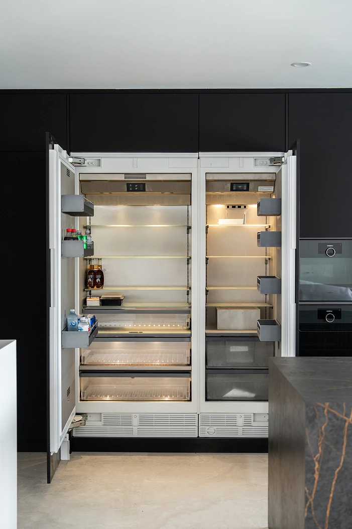 Integrated fridge set into black handleless kitchen cabinetry