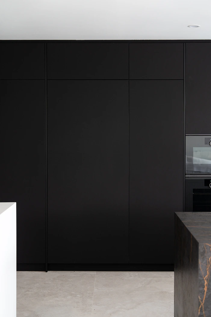 Floor to ceiling black handleless kitchen cabinetry