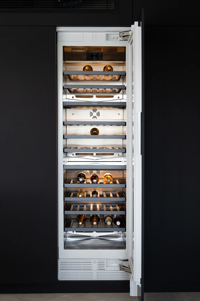 Integrated wine fridge in black kitchen cabinetry