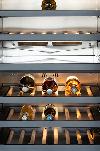 Close-up of a lit wine fridge with bottles