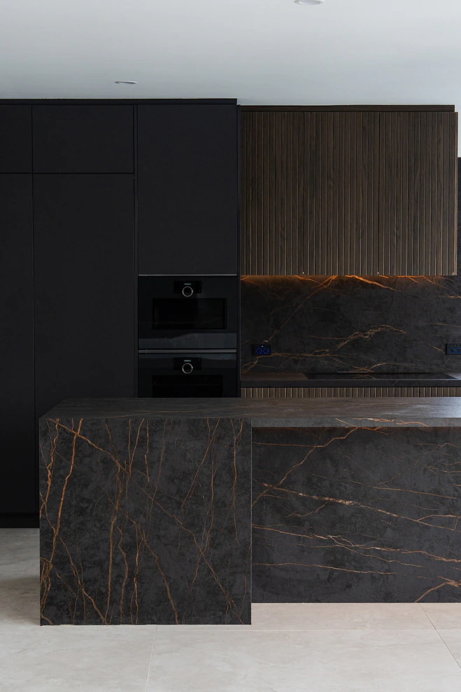 Dark stone island bench with fluted timber overhead cabinet