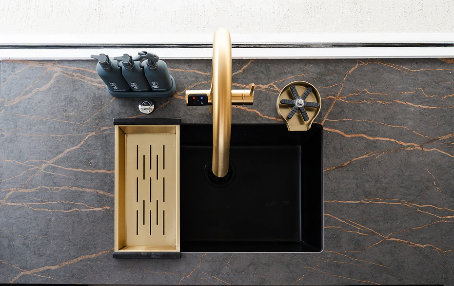 Custom joinery Sydney: brass kitchen tap with black sink set in dark veined stone